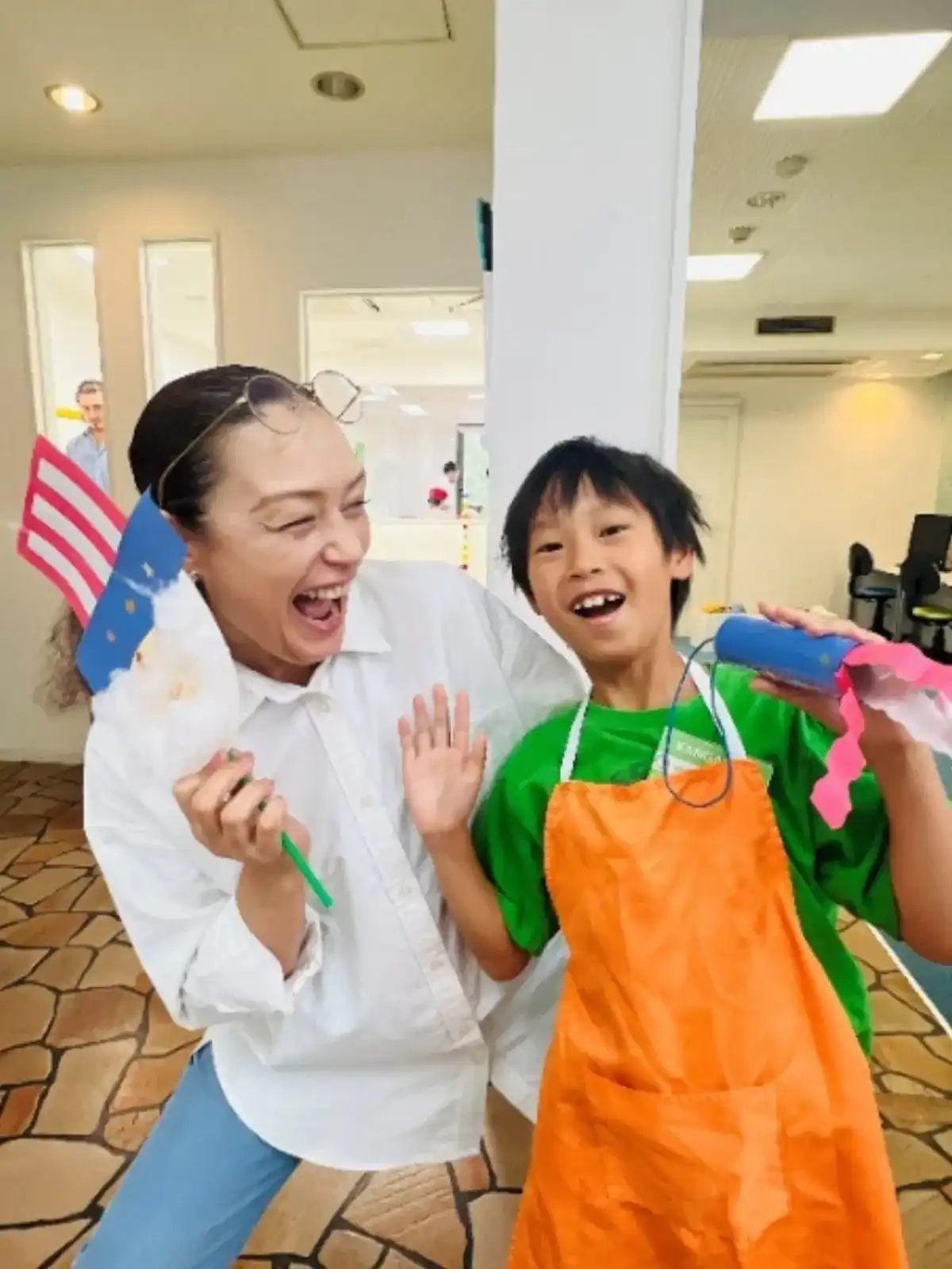 エプロン姿で笑う子どもと講師