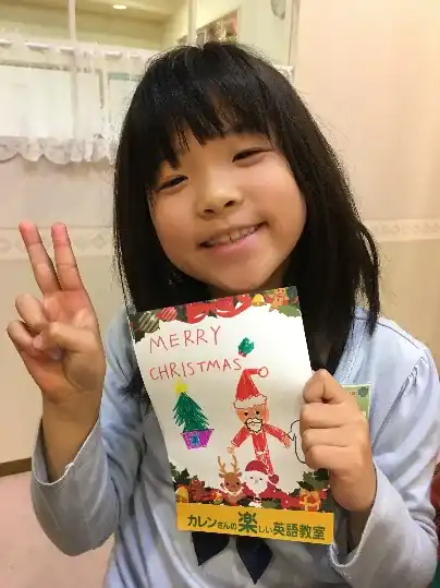 手づくりのクリスマスカードを持つ子ども